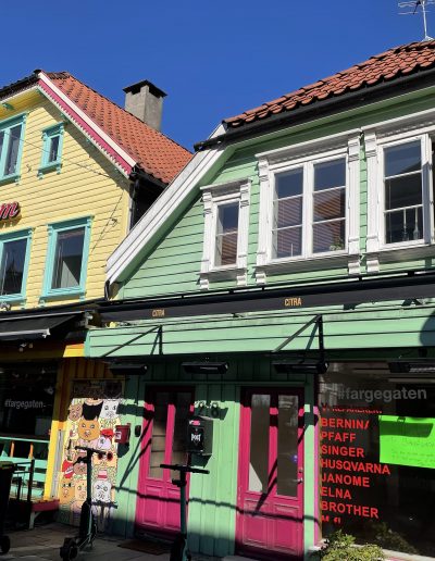 olourful wooden buildings along a street in Stavanger, Norway, showing traditional architecture.